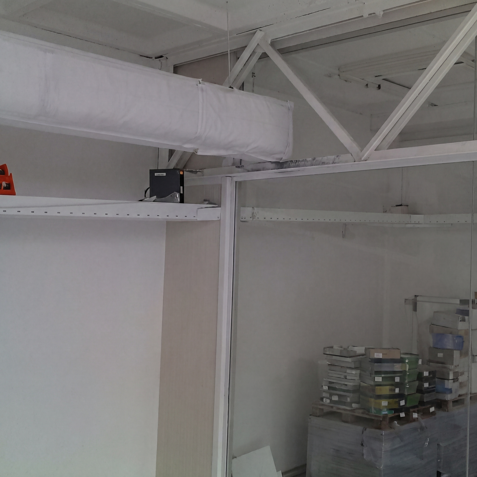 Detail van de hardglazen kantoorwand onder de bestaande staalconstructie