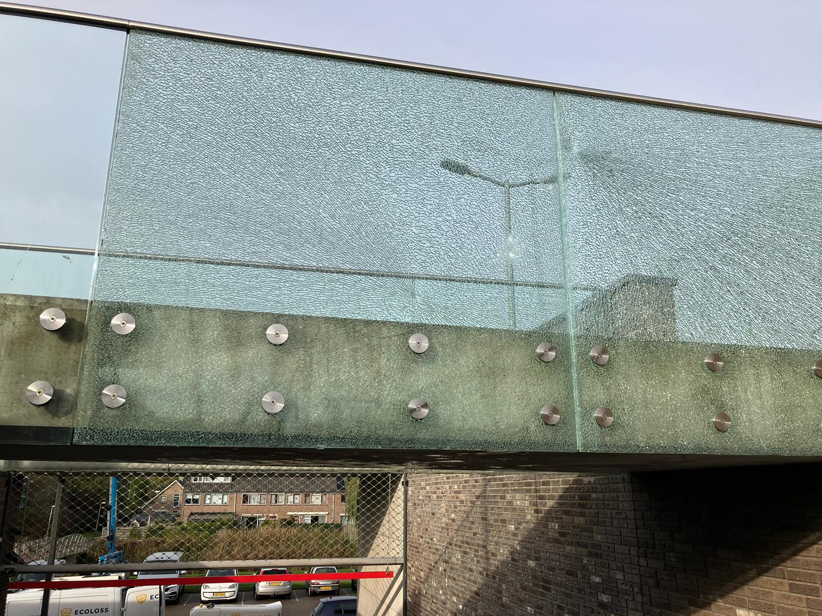 Gebroken gelaagde glasplaat in de bestaande balustrade van winkelcentrum Zijdelwaard vóór vervanging